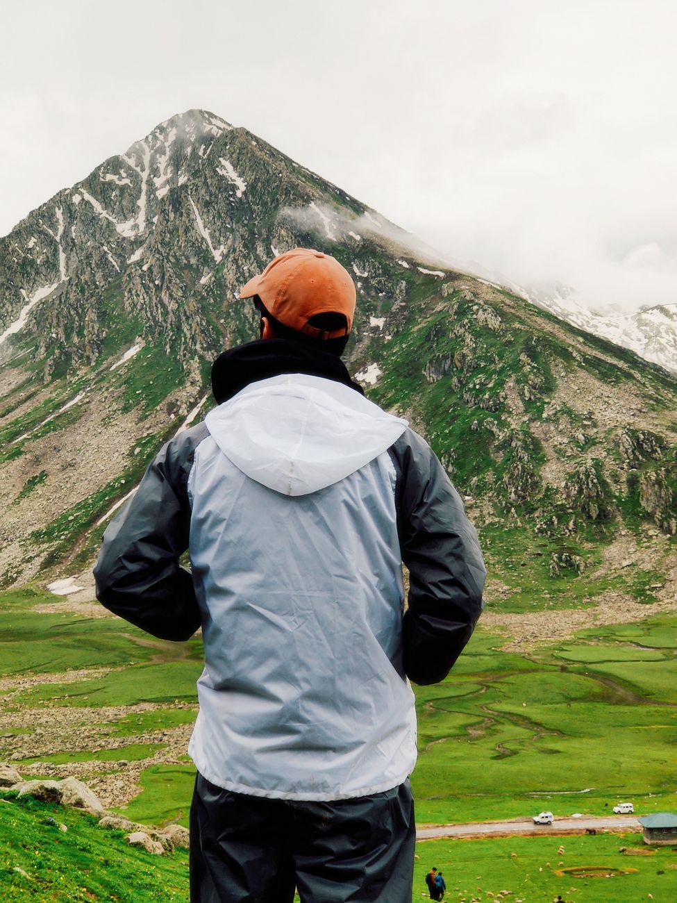 A traveler observing a tranquil mountain valley